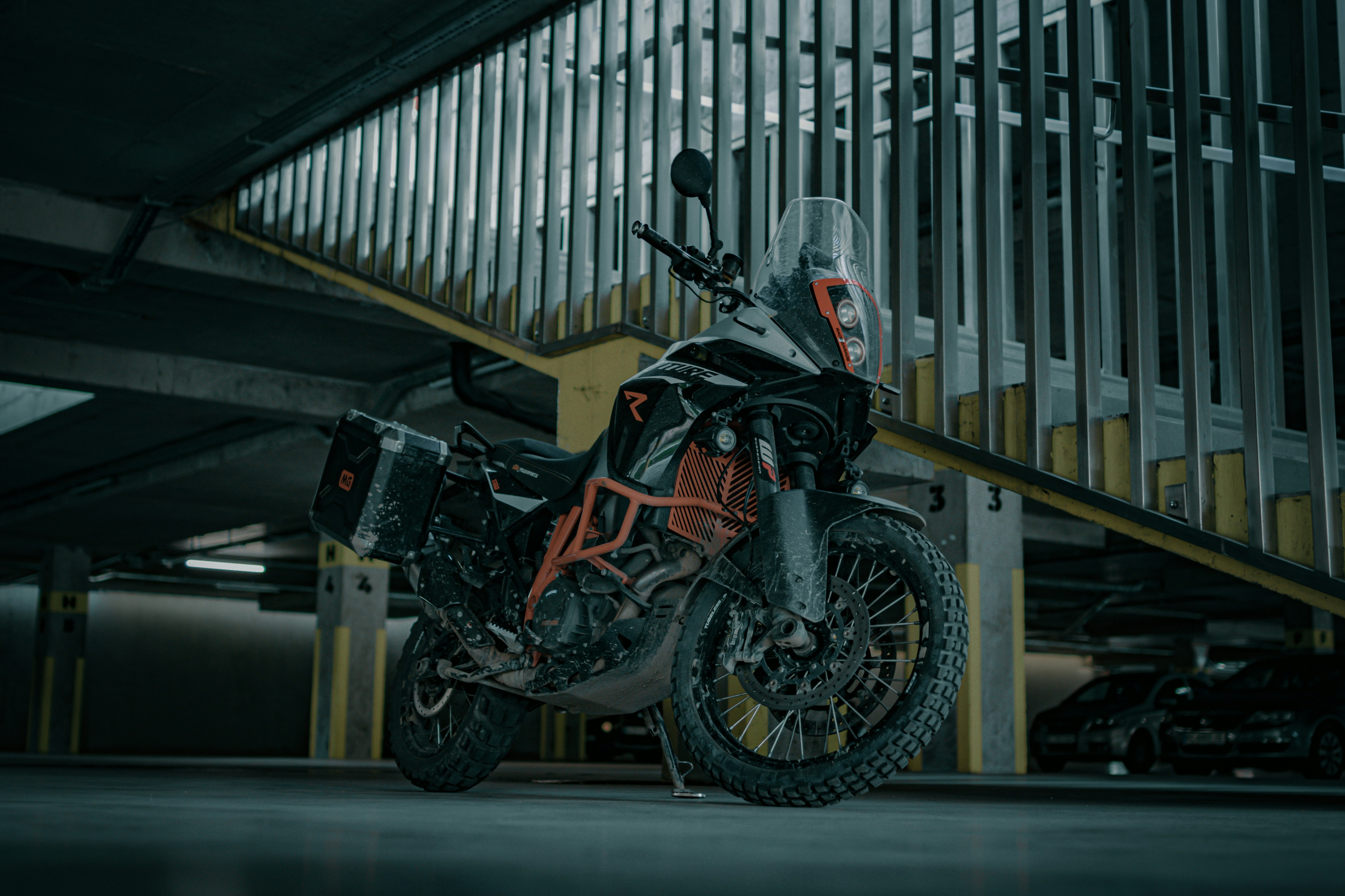 black and red sports bike parked beside white metal fence